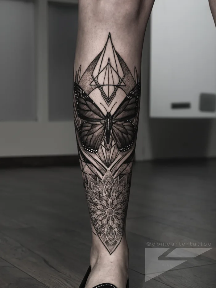 Blackwork geometric and dotwork piece with a butterfly and sacred geometry on the leg