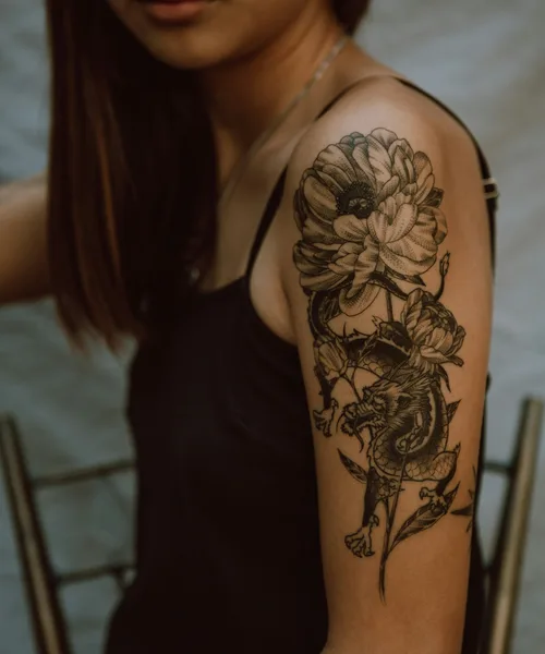 Fine line botanical forearm piece with delicate shading by Lena Voss